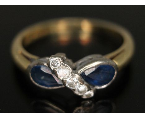 An 18ct gold sapphire and diamond ring, two pear cut sapphries weighing approx. 0.54 carats each, split by a row of five diam