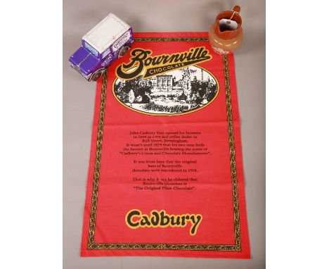 An Assortment of Cadbury Items:-Ceramic Cadbury Jug-Cadbury's Mini Fingers Tin Truck-Cadbury Bournville Chocolate Tea Towel. 