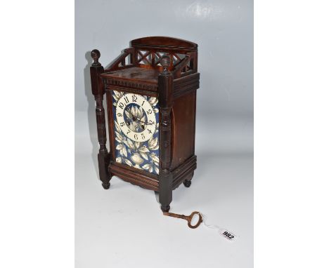 A WOODEN CASED CLOCK WITH AN ENAMELLED PLATE FACE with Arabic numerals and foliate patterns on a blue ground, key and pendulu