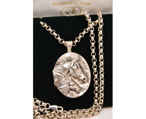 A SILVER LOCKET NECKLACE, an oval locket with embossed horse detail, fitted with a tapered bail, suspended from a silver belc