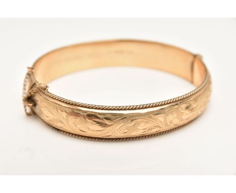A 9CT GOLD HINGED BANGLE, foliate pattern with rope twist rim, fitted with a push button clasp and additional safety chain, h