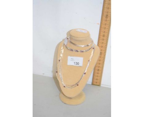 A white metal necklace and bangle together with accompanying stand