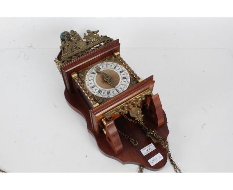 20th century wall clock with a silvered dial and Roman numerals, the top decorated with a classical figure holding a ball&nbs