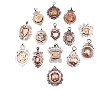 Fourteen silver fobs of various form, mostly early 20th century examples to include a fold faced example detailed with a figu