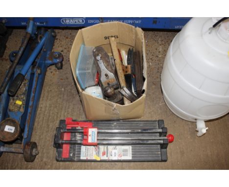 A box containing a tile cutter; a Stanley plane; various hand tools etc.