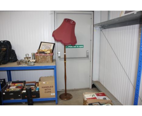 A teak standard lamp with shade