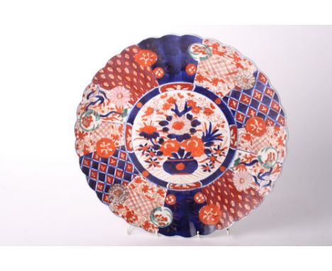 A 19th Century Imari porcelain charger with scalloped edge and central bowl of flowers, 15 1/2" dia