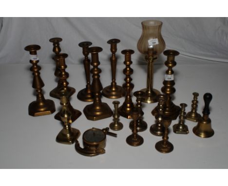A number of brass candlesticks, a candle lamp and an anchor cased barometer