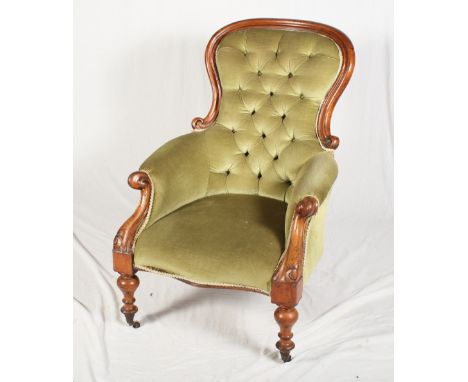 A Victorian mahogany showframe armchair, button upholstered in a green velour, on turned and castored supports