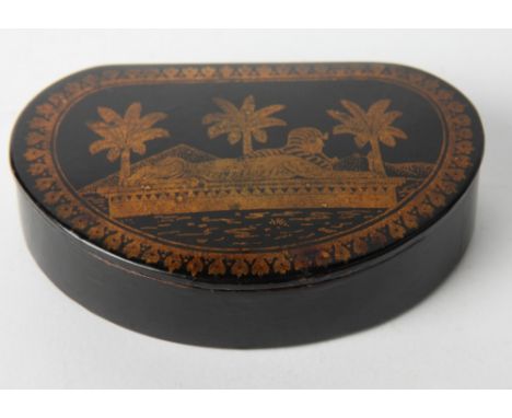 An ebonised and gilt decorated papier-mâché snuff box decorated palm trees and Sphinx, 4 1/2" wide