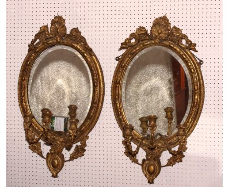 A pair of early Victorian oval gilt gesso decorated three-light girandoles with shell and scroll decorated surmounts,32" high