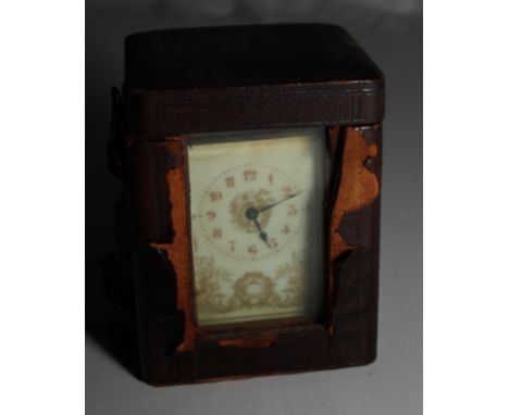 A brass framed carriage clock with gilt decorated cream dial and travelling case