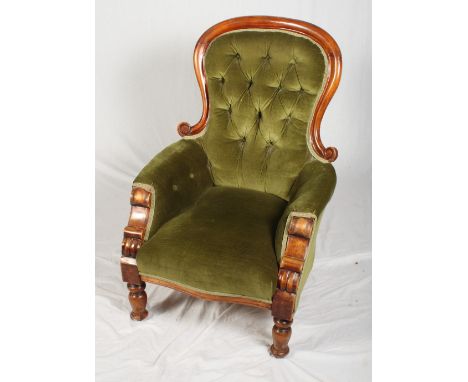 A Victorian mahogany showframe armchair, button upholstered in a green velour, on turned supports