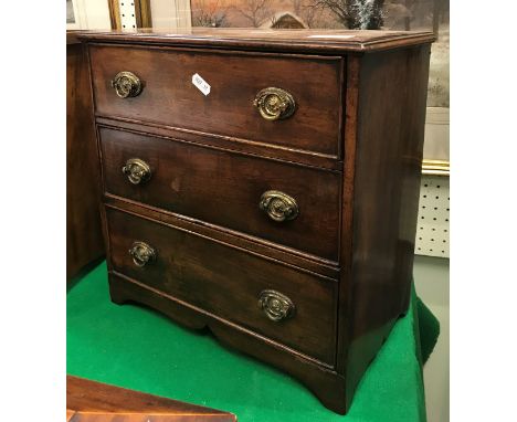 A 19th Century mahogany miniature square front chest of three drawers with embossed brass swan neck handles raised on bracket