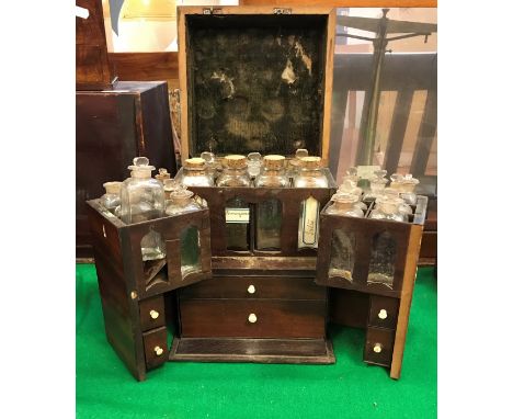 A 19th Century mahogany apothecary's cabinet with box wood stringing opening to reveal two fitted doors each with seven bottl