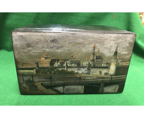 A 19th Century Russian lacquered tea caddy, the main body black, the top decorated with the Kremlin