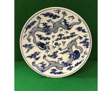 A 19th Century Chinese Daoguang (1821-1850) blue and white porcelain charger decorated with five toed dragons amongst clouds,