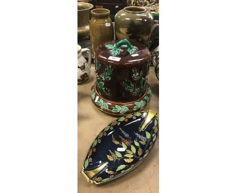 A Majolica holly decorated cheese dome and cover, a Carltonware boat shaped dish, a hand painted pottery vase with figure on 
