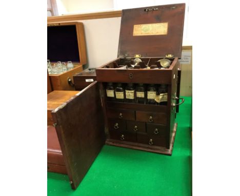 A 19th Century mahogany apothecary's chest, the top with herringbone banding and moulded edge opening to reveal scales, four 