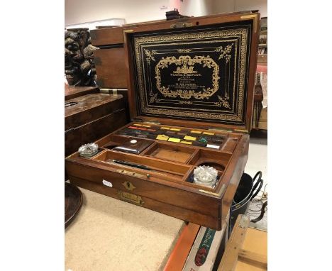 A late Victorian mahogany artist's box the figured top with brass inlaid medallion opening to reveal and embossed leather lab