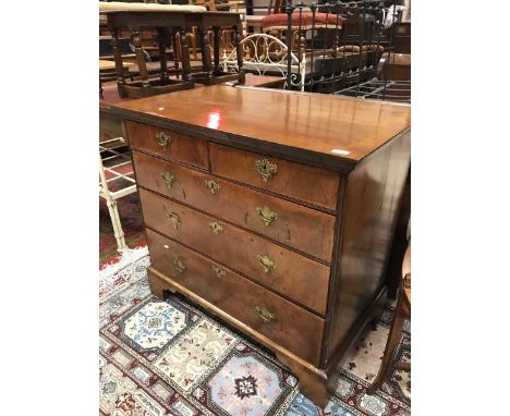 An early 18th Century walnut chest of two short and three long feather banded drawers on bracket feet (top later - converted 