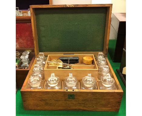 A late Victorian oak-cased apothecary's chest of rectangular form, opening to reveal a fitted interior with eleven bottles an