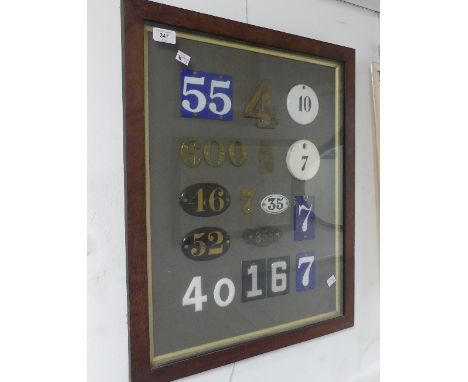 An attractive display of vintage House Numbers, including individual brass numbers, enamel and ceramic plaques, framed and gl