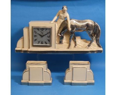 An Art Deco ceramic mantle Clock Garniture, cream ground, depicting a lady and cow, flanked by corresponding vases, H 22cm 