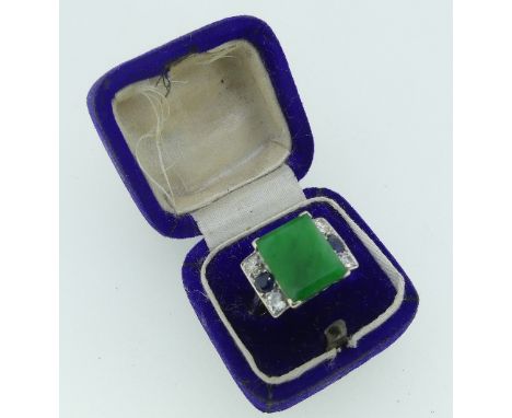 An emerald, sapphire and diamond Ring,&nbsp;the central emerald 12.25mm x 10mm appprox., with two diamonds and a sapphire set