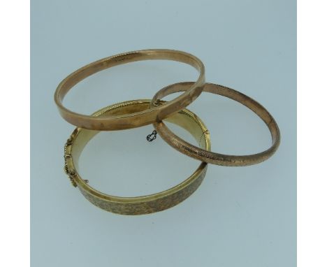 A 9ct yellow gold hollow hinged Bangle, the front with foliate engraved decoration, together with a narrow 9ct rose gold holl