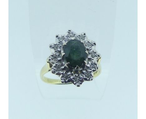 A green tourmaline and diamond Cluster Ring, the oval facetted tourmaline, approx 8mm long, surrounded by twelve small illusi