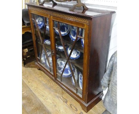 An early 20thC mahogany glazed Bookcase, the incised top, upon astragal glazed doors, all raised on bracket feet, 48in (124cm