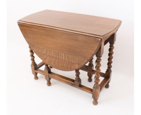 An oak gate-leg table - 1920s, the oval dropflap top raised on barleytwist supports with turned baluster feet. (LWH 84 x 46 x