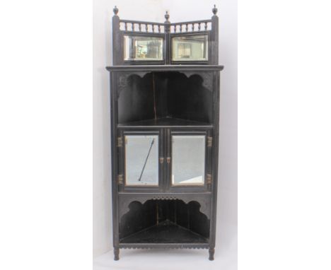 An Edwardian ebonised corner cabinet - the mirrored, spindle back over an open upper shelf, two-door mirrored cupboard below 