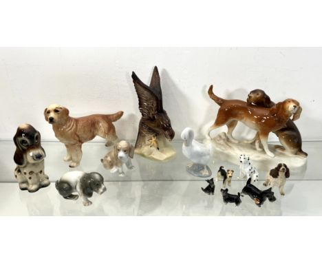 A collection of bone china and pottery figures of dogs - 1960s-90s, including a Royal Dux group with two hunting dogs, green 