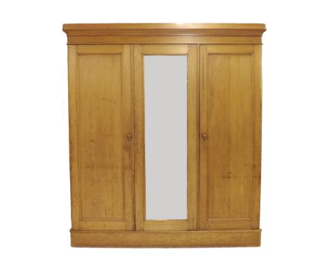 Heals late 19th/early 20th century pine triple front wardrobe/press, the central mirrored panel flanked by twin panelled door