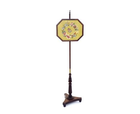 19th century mahogany pole fire screen with framed woolwork panel upon a wrythen fluted column and triform plateau, 57" high