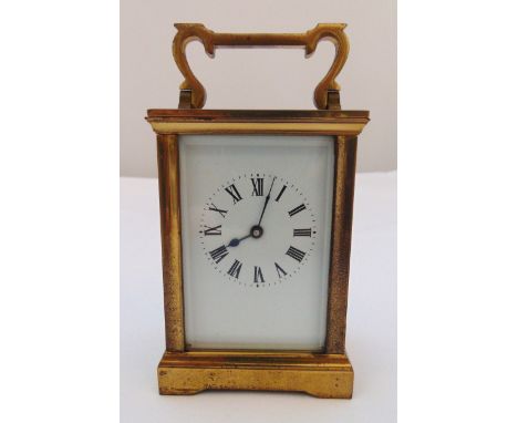 A brass carriage clock of customary form with white enamel dial and Roman numerals 15cm (h)