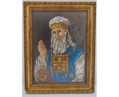 A framed and glazed wool tapestry of a high priest holding an incense burner, Dingleys label verso, 45 x 33cm