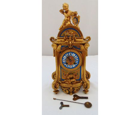A French gilded metal mantle clock with painted panels, the porcelain dial with Roman numerals surmounted by a putti supporti