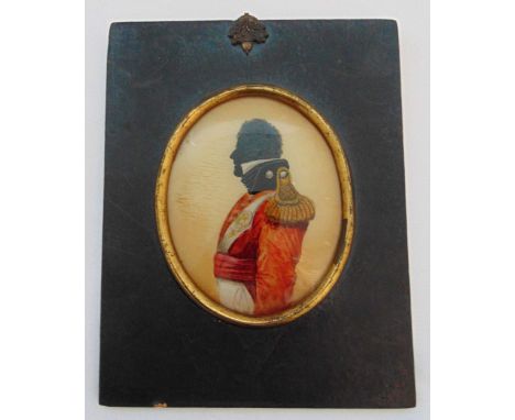 A framed oval portrait miniature of a military officer in silhouette profile with gold epaulettes, reverse painted on glass, 