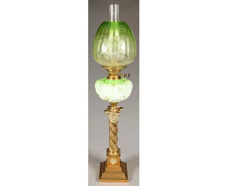 AN EDWARDIAN BRASS COLUMNAR OIL LAMP WITH MOULDED GREEN GLASS FOUNT AND BRASS DUPLEX BURNER, THE SPIRALLY REEDED SHAFT WITH C