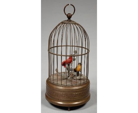 A CLOCKWORK SINGING BIRDS-IN-A-CAGE AUTOMATON, THE BRASS AND WIRE BIRDCAGE WITH EMBOSSED BASE ON THREE FEET, CONTAINING RED A