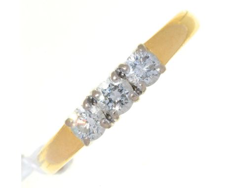 A THREE STONE DIAMOND RING, WITH ROUND BRILLIANT CUT DIAMONDS, THAT TO THE CENTRE WEIGHING APPROXIMATELY 0.20CT, IN 18CT GOLD