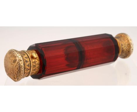 A VICTORIAN GILT SILVER COLOURED METAL MOUNTED RUBY GLASS DOUBLE ENDED SCENT-AND SALTS-BOTTLE, WITH ENGRAVED CAPS, 14CM L, C1