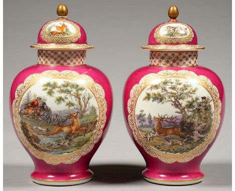 A PAIR OF GERMAN PORCELAIN MAGENTA GROUND&nbsp;JARS AND COVERS, PAINTED WITH A HUNTING SCENE OR FLOWERS, 25CM H, UNDERGLAZE B