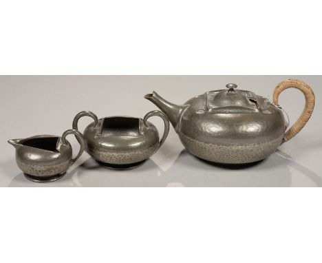 A LIBERTY &amp; CO TUDRIC PEWTER TEA SERVICE, COMPRISING TEAPOT, SUGAR BOWL AND MILK JUG, TEAPOT WITH WICKER WRAPPED HANDLE, 