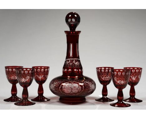 A BOHEMIAN RUBY FLASHED AND FACET CUT GLASS DECANTER AND STOPPER AND SIX WINE GLASSES EN SUITE, ENGRAVED WITH STYLISED FLOWER