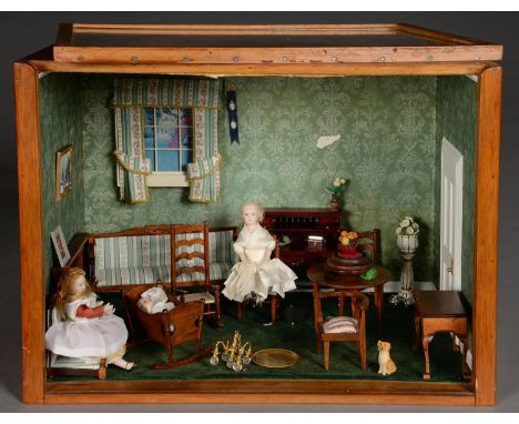 DIORAMA. A FURNISHED DOLL'S SITTING ROOM IN EARLY VICTORIAN STYLE, WITH CHAIRS, TABLE, DESK, ORNAMENTS AND TWO DOLLS, IN VARN