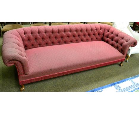 A red fabric upholstered Chesterfield sofa with button back on ball and claw supports 